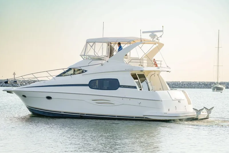  Yacht Photos Pics 2003 Silverton 410 Sport Bridge yacht cruising on calm waters.