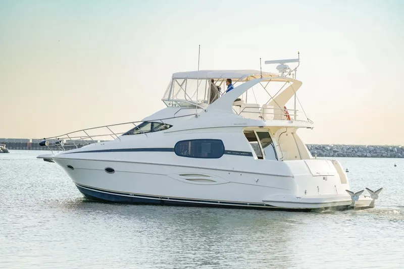  Yacht Photos Pics 2003 Silverton 410 Sport Bridge yacht cruising on calm waters at sunset.