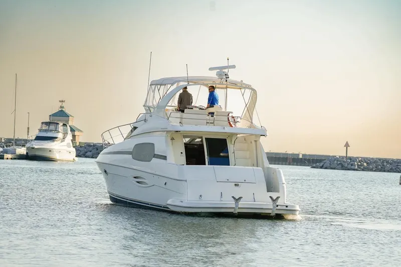  Yacht Photos Pics 2003 Silverton 410 Sport Bridge yacht cruising in a serene marina at sunset.