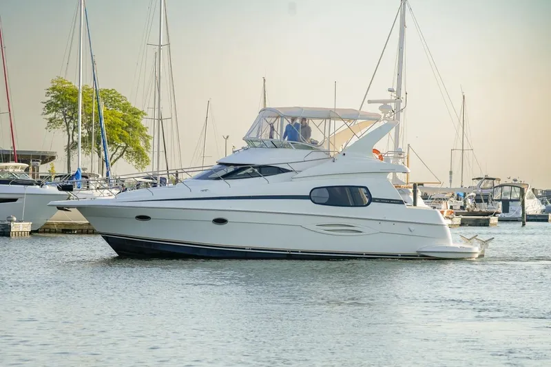  Yacht Photos Pics 2003 Silverton 410 Sport Bridge yacht docked in a marina, surrounded by sailboats.