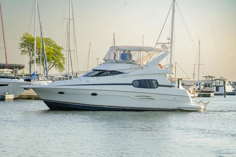  Yacht Photos Pics 2003 Silverton 410 Sport Bridge yacht docked in a marina with sailboats.