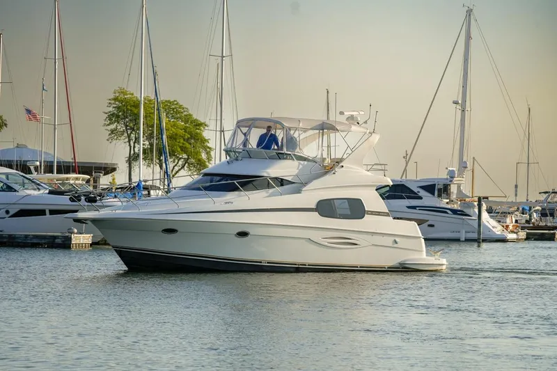  Yacht Photos Pics 2003 Silverton 410 Sport Bridge yacht docked in a marina with sailboats.