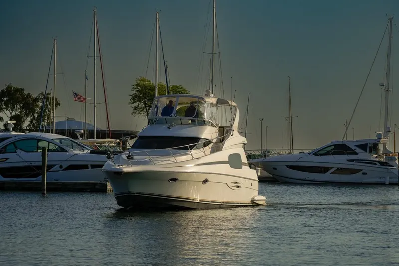  Yacht Photos Pics 2003 Silverton 410 Sport Bridge yacht docked in a marina with sailboats.