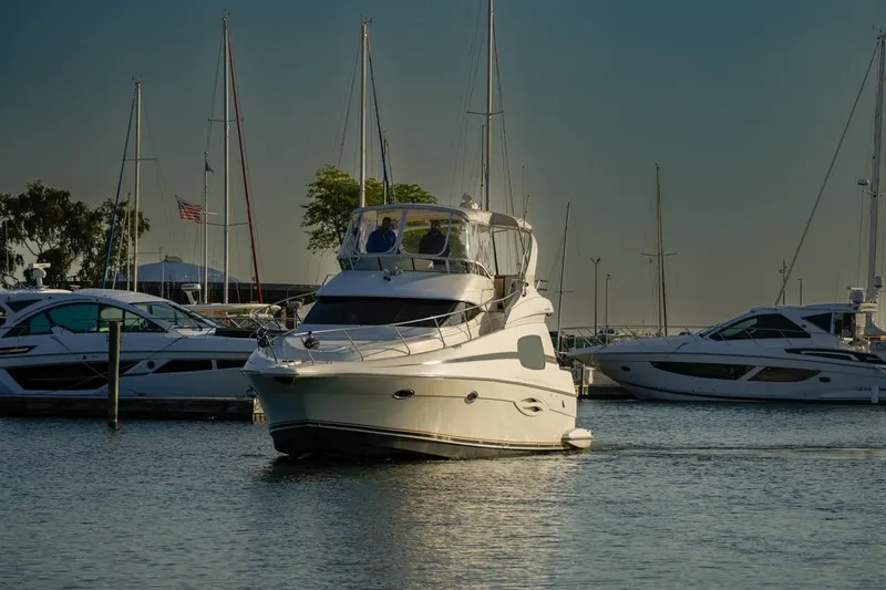  Yacht Photos Pics 2003 Silverton 410 Sport Bridge yacht docked in a marina with sailboats.