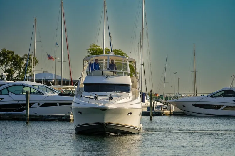  Yacht Photos Pics 2003 Silverton 410 Sport Bridge yacht docked in a marina with sailboats.