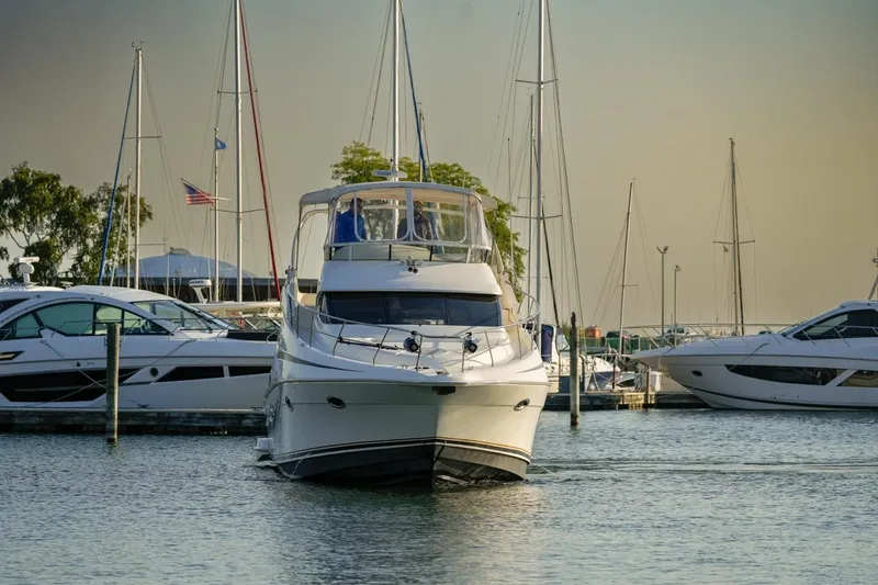  Yacht Photos Pics 2003 Silverton 410 Sport Bridge yacht docked in a marina with sailboats.