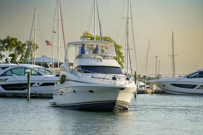  Yacht Photos Pics 2003 Silverton 410 Sport Bridge yacht docked in a marina with sailboats.