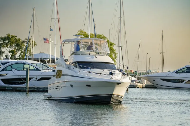  Yacht Photos Pics 2003 Silverton 410 Sport Bridge yacht docked in a marina with other boats.