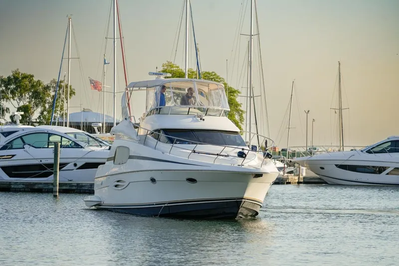  Yacht Photos Pics 2003 Silverton 410 Sport Bridge yacht docked in a marina with other boats.