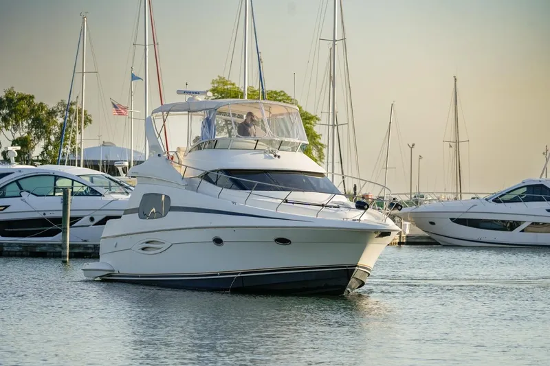  Yacht Photos Pics 2003 Silverton 410 Sport Bridge yacht docked in a marina with sailboats.