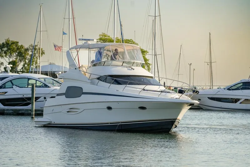  Yacht Photos Pics 2003 Silverton 410 Sport Bridge yacht docked in a marina with other boats.