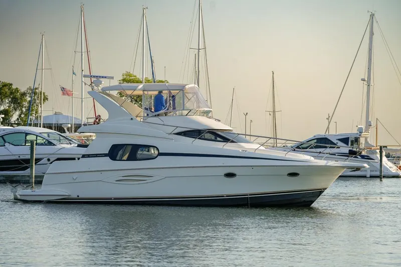  Yacht Photos Pics 2003 Silverton 410 Sport Bridge yacht docked in a marina, surrounded by sailboats.