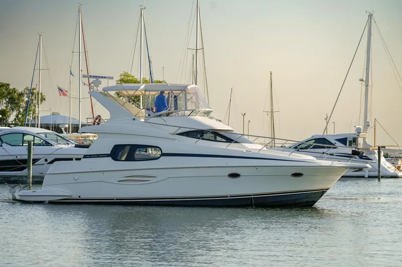  Yacht Photos Pics 2003 Silverton 410 Sport Bridge yacht docked in a marina with sailboats.