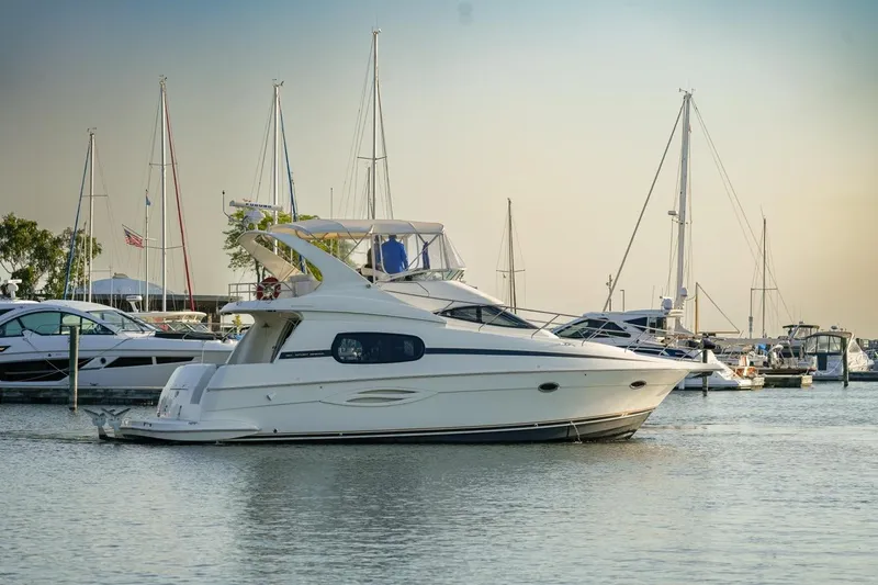  Yacht Photos Pics 2003 Silverton 410 Sport Bridge yacht docked in a marina with sailboats.