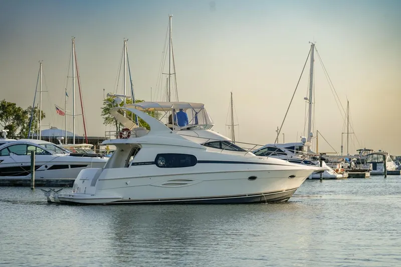 Yacht Photos Pics 2003 Silverton 410 Sport Bridge yacht docked in a marina with sailboats.