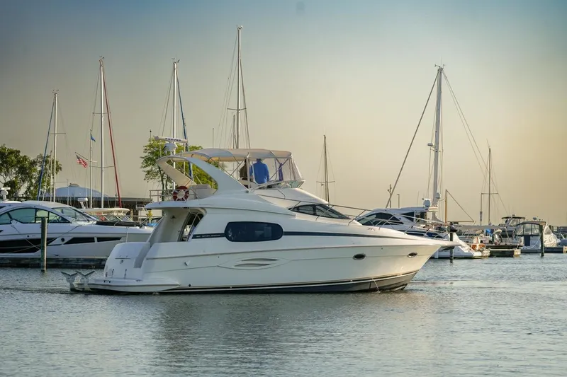  Yacht Photos Pics 2003 Silverton 410 Sport Bridge yacht docked in a marina with sailboats.