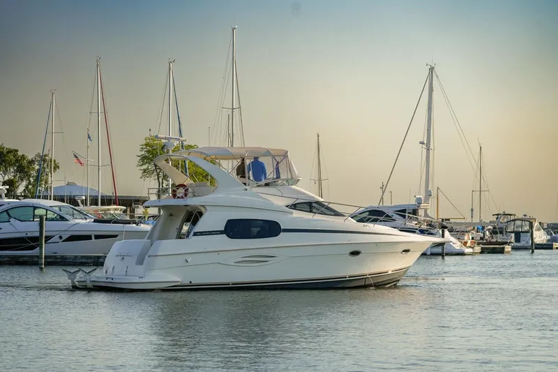  Yacht Photos Pics 2003 Silverton 410 Sport Bridge yacht docked in a marina with sailboats.