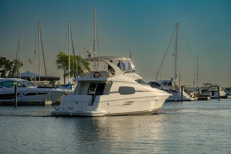  Yacht Photos Pics 2003 Silverton 410 Sport Bridge yacht docked in a marina, surrounded by sailboats.