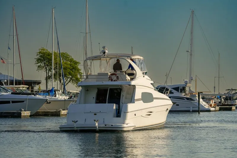  Yacht Photos Pics 2003 Silverton 410 Sport Bridge yacht docked in a marina with sailboats.