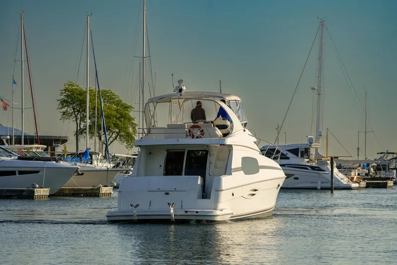  Yacht Photos Pics 2003 Silverton 410 Sport Bridge yacht in marina, surrounded by sailboats.
