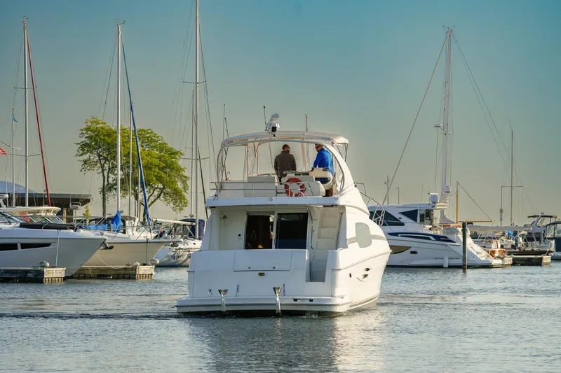  Yacht Photos Pics 2003 Silverton 410 Sport Bridge yacht in a marina, surrounded by sailboats.