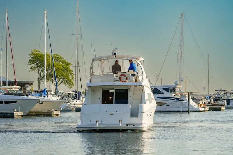  Yacht Photos Pics 2003 Silverton 410 Sport Bridge yacht in marina, surrounded by sailboats.