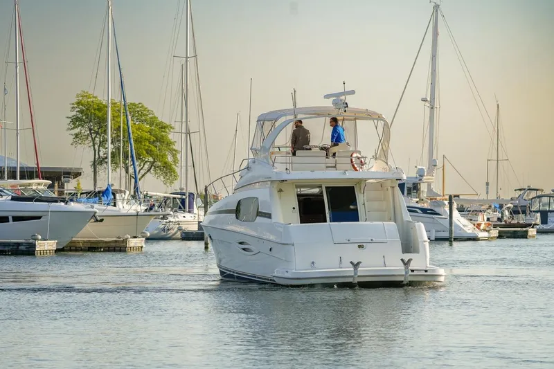  Yacht Photos Pics 2003 Silverton 410 Sport Bridge yacht in a marina, surrounded by sailboats.