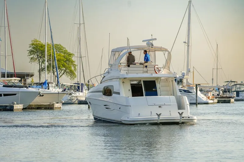  Yacht Photos Pics 2003 Silverton 410 Sport Bridge yacht in a marina, surrounded by sailboats.