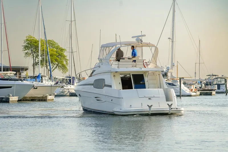  Yacht Photos Pics 2003 Silverton 410 Sport Bridge yacht in a marina, surrounded by sailboats.