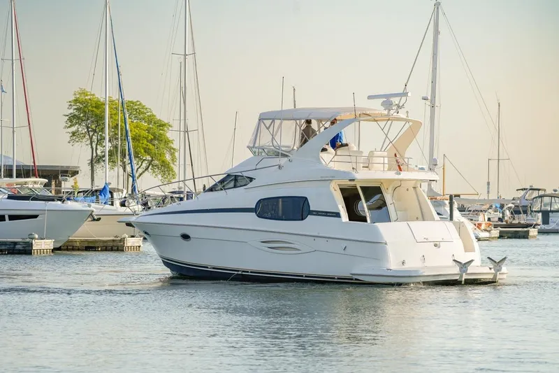  Yacht Photos Pics 2003 Silverton 410 Sport Bridge yacht docked in a marina with sailboats.