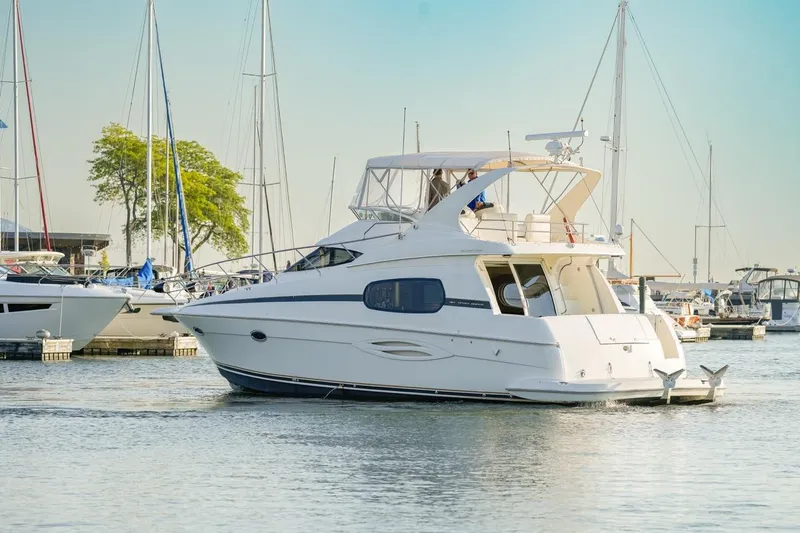  Yacht Photos Pics 2003 Silverton 410 Sport Bridge yacht docked in a marina, surrounded by sailboats.