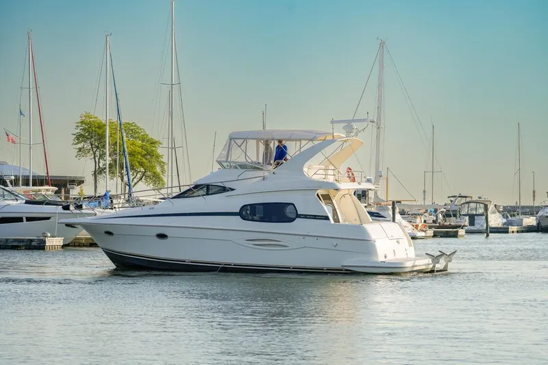  Yacht Photos Pics 2003 Silverton 410 Sport Bridge yacht docked in a marina with sailboats.