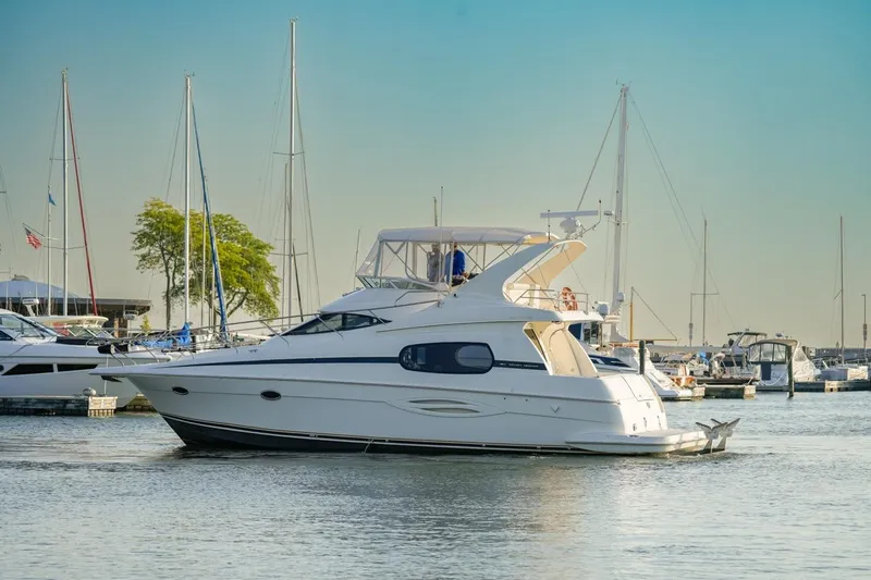  Yacht Photos Pics 2003 Silverton 410 Sport Bridge yacht docked in a marina under clear skies.