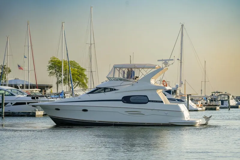  Yacht Photos Pics 2003 Silverton 410 Sport Bridge yacht docked in a marina with sailboats.