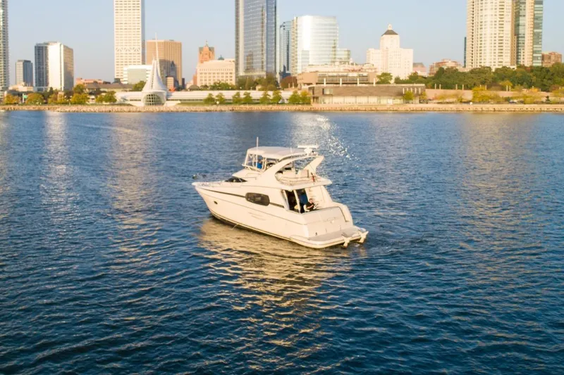  Yacht Photos Pics 2003 Silverton 410 Sport Bridge yacht cruising near city skyline.