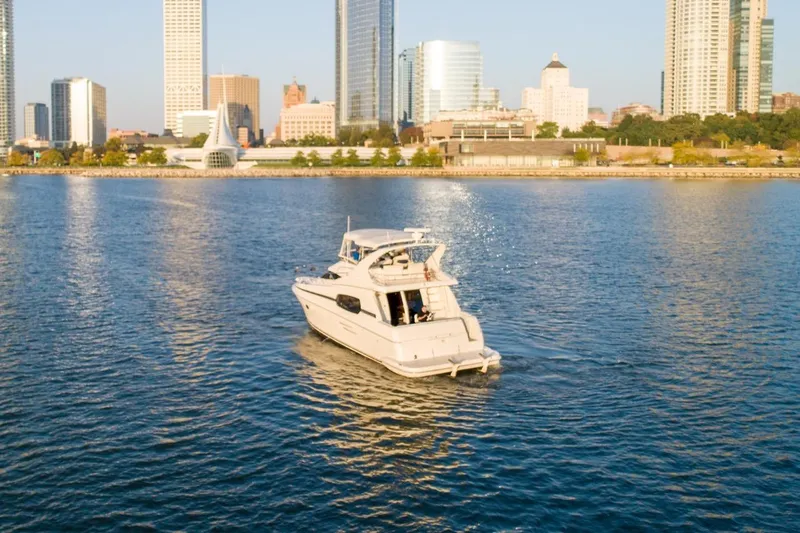  Yacht Photos Pics 2003 Silverton 410 Sport Bridge yacht cruising near city skyline.