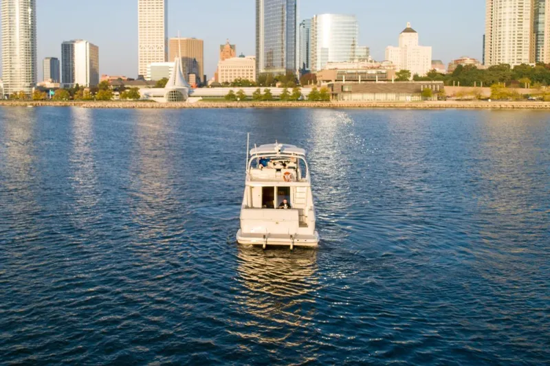  Yacht Photos Pics 2003 Silverton 410 Sport Bridge yacht cruising near city skyline.