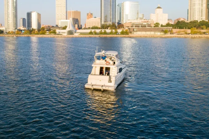  Yacht Photos Pics 2003 Silverton 410 Sport Bridge yacht cruising near city skyline.