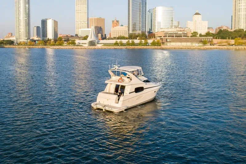  Yacht Photos Pics 2003 Silverton 410 Sport Bridge yacht cruising near city skyline.