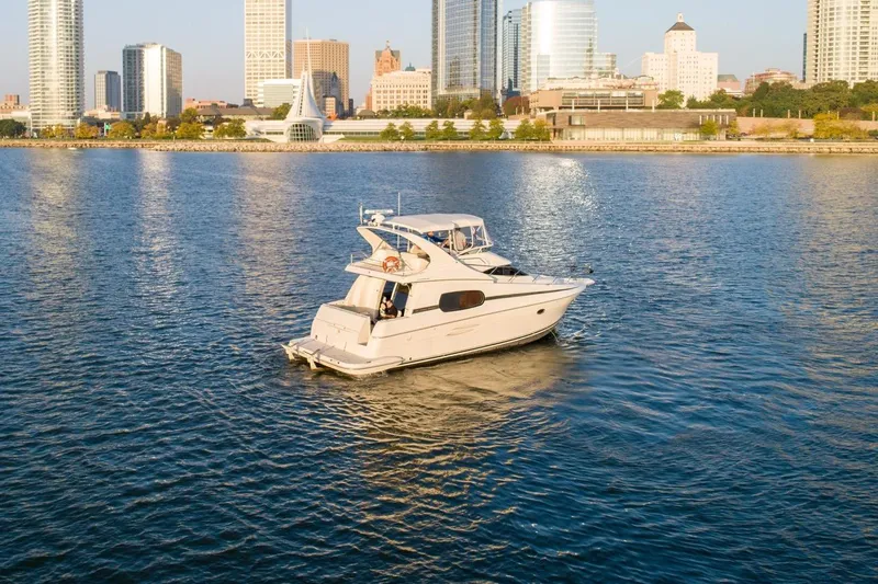  Yacht Photos Pics 2003 Silverton 410 Sport Bridge yacht cruising near city skyline.