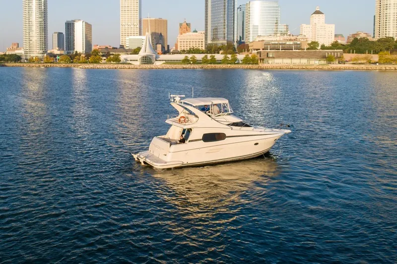  Yacht Photos Pics 2003 Silverton 410 Sport Bridge yacht on urban waterfront with city skyline.