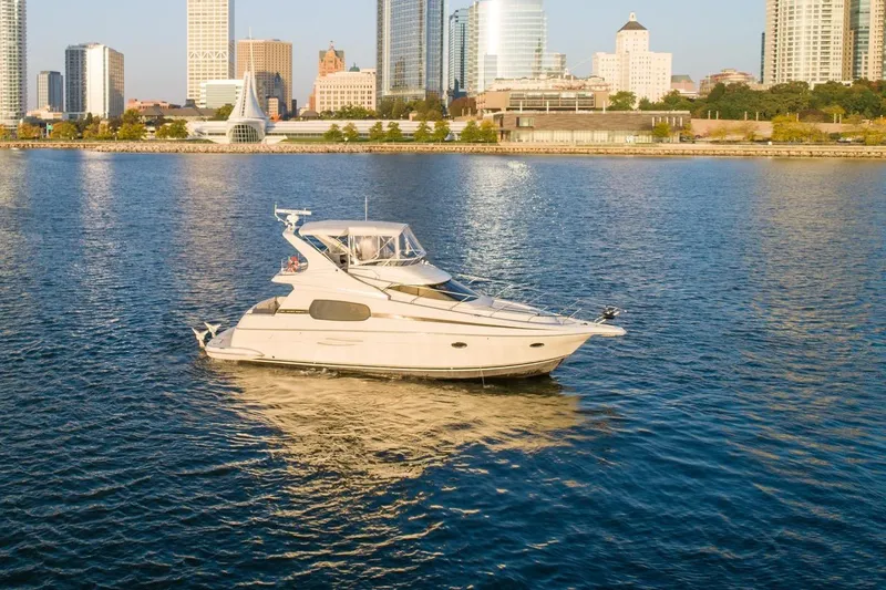  Yacht Photos Pics 2003 Silverton 410 Sport Bridge yacht cruising near city skyline.