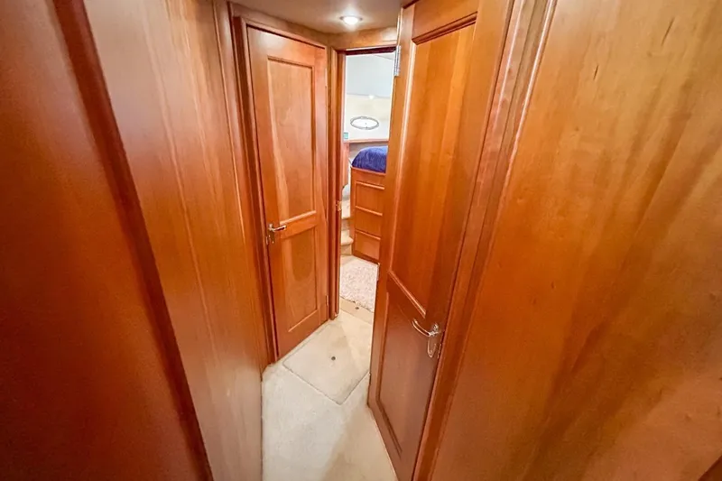 Yacht Photos Pics Interior hallway of 2003 Silverton 410 Sport Bridge with wooden doors and carpeted floor.