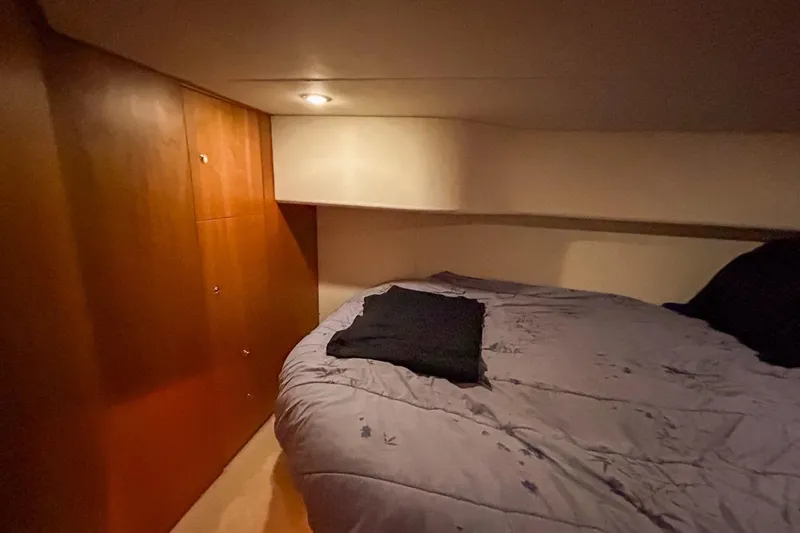  Yacht Photos Pics Cozy cabin interior of 2003 Silverton 410 Sport Bridge with wooden cabinetry and bed.