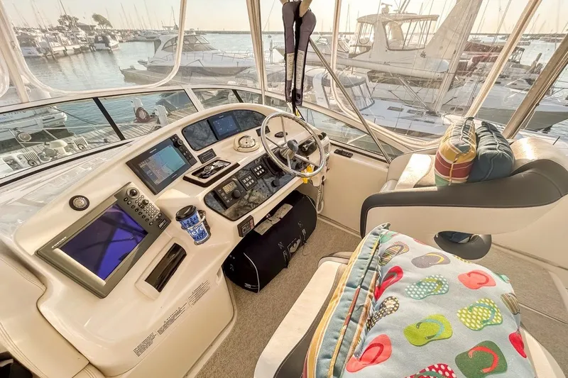  Yacht Photos Pics 2003 Silverton 410 Sport Bridge helm with modern controls, marina view, and colorful cushions.