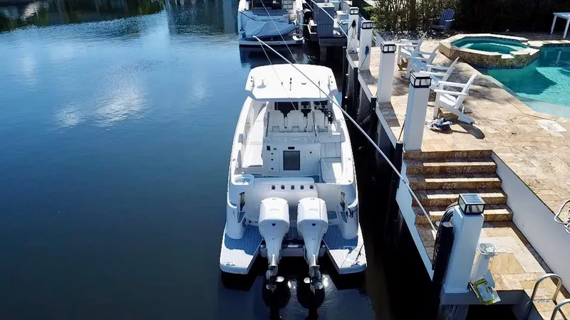 All Gas No Brakes Yacht Photos Pics 2020 Regal 33 SAV boat docked by a poolside, featuring dual outboard engines.