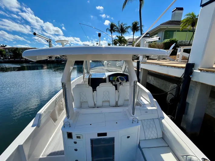 All Gas No Brakes Yacht Photos Pics 2020 Regal 33 SAV boat docked by waterfront homes under a clear blue sky.