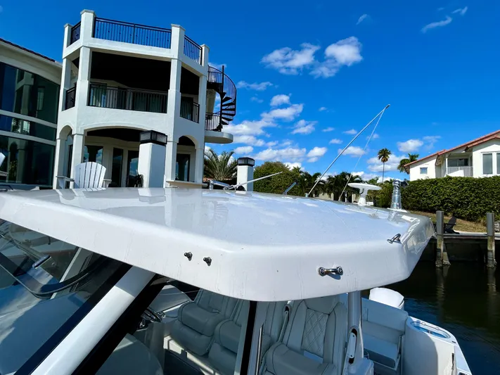 All Gas No Brakes Yacht Photos Pics 2020 Regal 33 SAV boat docked near waterfront homes under blue sky.