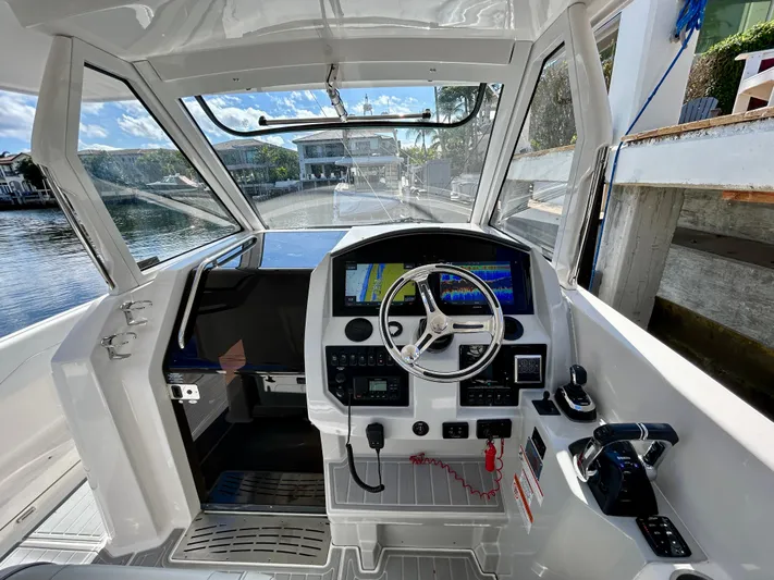 All Gas No Brakes Yacht Photos Pics 2020 Regal 33 SAV boat cockpit with modern navigation system and steering wheel.