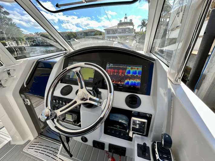 All Gas No Brakes Yacht Photos Pics 2020 Regal 33 SAV boat cockpit with steering wheel and navigation display.